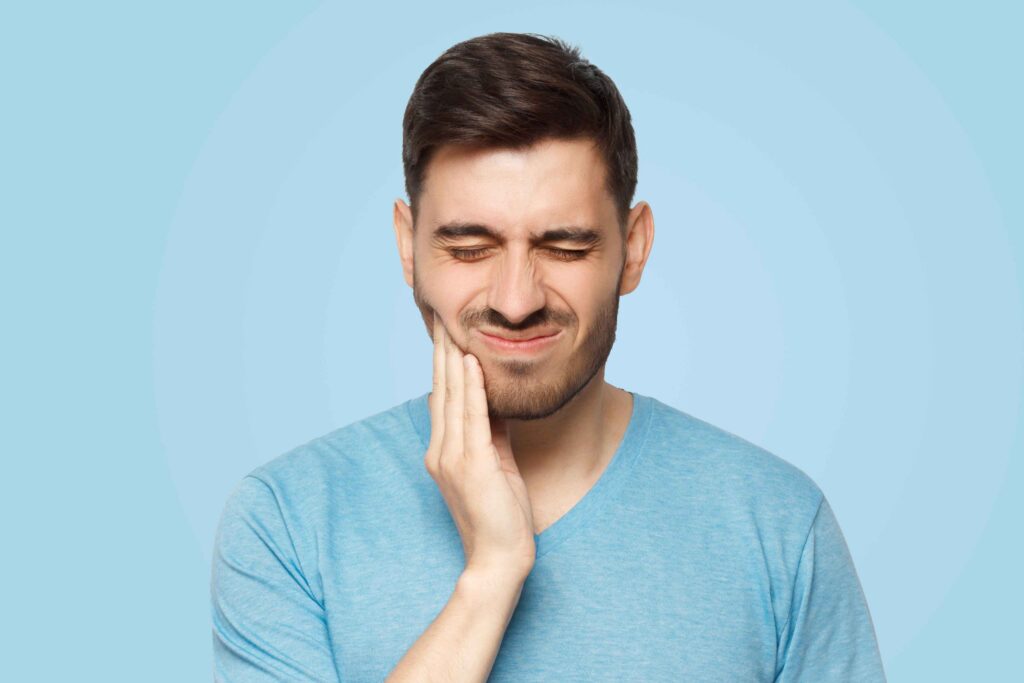 Man holding his jaw with tooth pain.